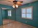 Bright bedroom features a ceiling fan, tile flooring and mirrored closet at 3357 Hunt Club Dr, Clearwater, FL 33761