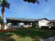 Attractive single-story home showcasing a manicured lawn, stone accents, and vibrant, lush landscaping at 3357 Hunt Club Dr, Clearwater, FL 33761