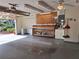 Well-lit garage with workbench, overhead storage, painted floors, and attached storage at 3357 Hunt Club Dr, Clearwater, FL 33761