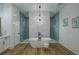Elegant primary bathroom featuring a freestanding tub, walk-in shower, and modern chandelier at 3515 Powerline Rd, Lithia, FL 33547