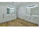 Bright bathroom with double vanity, wood-look floors, and modern fixtures at 3515 Powerline Rd, Lithia, FL 33547