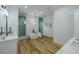 Elegant primary bathroom featuring a freestanding tub, walk-in shower, and modern chandelier at 3515 Powerline Rd, Lithia, FL 33547