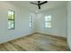 Bright bedroom features beautiful wood floors, three windows, and a modern ceiling fan at 3515 Powerline Rd, Lithia, FL 33547