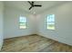 Bright bedroom features beautiful wood floors, two windows, and a modern ceiling fan at 3515 Powerline Rd, Lithia, FL 33547