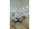 A dining area featuring hardwood floors, a modern chandelier, and seating for eight at 3515 Powerline Rd, Lithia, FL 33547