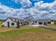 Wide exterior shot shows the expansive, well-manicured front lawn, and the home's detailed design at 3515 Powerline Rd, Lithia, FL 33547