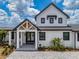 Close exterior of front entrance with glass doors, covered porch, stone pavers, and well-kept landscaping at 3515 Powerline Rd, Lithia, FL 33547