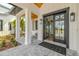 Inviting front porch with double glass doors, stylish lighting, swing and large pillars at 3515 Powerline Rd, Lithia, FL 33547