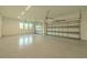 Open garage showcasing a clean design with plenty of space, including epoxy flooring and windows at 3515 Powerline Rd, Lithia, FL 33547