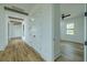 Hallway with wood floors, beam ceiling, storage, and leading into a bedroom with ceiling fan and window at 3515 Powerline Rd, Lithia, FL 33547