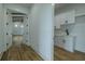Hallway with light colored plank flooring leading to laundry room with white cabinets at 3515 Powerline Rd, Lithia, FL 33547