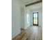 Bright hallway with light wood flooring, white shiplap walls, and a rustic wood beam accent at 3515 Powerline Rd, Lithia, FL 33547