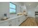 Modern white kitchen featuring marble countertops, stylish backsplash, and stainless steel appliances at 3515 Powerline Rd, Lithia, FL 33547