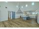 Bright, open living room flows into the kitchen, featuring modern lighting and hardwood flooring at 3515 Powerline Rd, Lithia, FL 33547