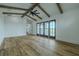 Living room with beautiful wood floors, vaulted ceilings, wood beams, and sliding doors to the lanai at 3515 Powerline Rd, Lithia, FL 33547