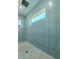 Sleek walk-in shower featuring blue tiling and a minimalist design, creating a spa-like experience at 3515 Powerline Rd, Lithia, FL 33547