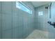 Walk-in shower with tiled walls, pebble floor, and window at 3515 Powerline Rd, Lithia, FL 33547