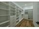 Spacious walk-in closet with custom shelving and wood flooring at 3515 Powerline Rd, Lithia, FL 33547