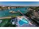 Aerial view of a backyard pool and spa with an adjacent boat dock and waterfront access at 3805 Gulf Blvd # 504, St Pete Beach, FL 33706