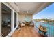 Private covered balcony featuring tile flooring, fan, seating, and stunning water views at 3805 Gulf Blvd # 504, St Pete Beach, FL 33706