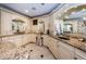 A luxurious bathroom featuring dual vanities, granite countertops, travertine floors and custom cabinets at 3805 Gulf Blvd # 504, St Pete Beach, FL 33706