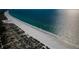 Scenic aerial shot of a white sand beach bordered by dunes and the sparkling ocean at 3805 Gulf Blvd # 504, St Pete Beach, FL 33706
