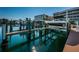 Scenic waterfront view featuring a boat lift with boat, set against buildings at 3805 Gulf Blvd # 504, St Pete Beach, FL 33706