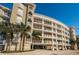 Multi-story building with palm trees, white balconies and subterranean parking at 3805 Gulf Blvd # 504, St Pete Beach, FL 33706