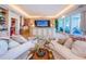 Elegant living area with custom built-ins, plush seating, and access to a waterfront balcony at 3805 Gulf Blvd # 504, St Pete Beach, FL 33706