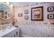 Charming powder room with decorative seashell accents, a decorative mirror, and a unique vanity at 3805 Gulf Blvd # 504, St Pete Beach, FL 33706