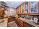 Elegant wet bar with granite countertops, wood cabinets, and a stainless-steel beverage cooler at 3805 Gulf Blvd # 504, St Pete Beach, FL 33706