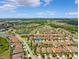 Expansive aerial view of a neighborhood with mature trees, and community lakes under a blue sky with scattered clouds at 3877 Burdick Loop, Odessa, FL 33556