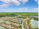 An aerial view showing this home's location within a beautiful neighborhood, mature trees and nearby community lake at 3877 Burdick Loop, Odessa, FL 33556