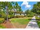 Well-maintained home exterior with green lawn, mature trees and partial sidewalk view at 3877 Burdick Loop, Odessa, FL 33556