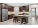 Modern kitchen with stainless steel appliances, a large island, and stylish dark wood cabinetry at 3877 Burdick Loop, Odessa, FL 33556