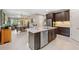 Open kitchen layout with stainless steel appliances, quartz counters, and view of the dining and living areas at 3877 Burdick Loop, Odessa, FL 33556
