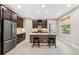 Modern kitchen with stainless steel appliances, a large island, and stylish dark wood cabinetry at 3877 Burdick Loop, Odessa, FL 33556