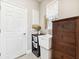 A clean laundry room with laundry sink, white cabinet, dark wood cabinet, macrame curtain and door at 3877 Burdick Loop, Odessa, FL 33556