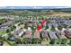 Aerial view of a home in a suburban neighborhood with lush greenery and a lake nearby at 4063 Medicci Ln, Wesley Chapel, FL 33543