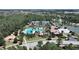 Aerial view showcasing a pool, park, lake, and tennis courts in a lush green community at 4063 Medicci Ln, Wesley Chapel, FL 33543