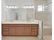 Bathroom featuring a double vanity with wood cabinets and a glass enclosed shower at 4063 Medicci Ln, Wesley Chapel, FL 33543