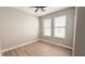 Bedroom featuring wood floors, neutral paint, two windows with blinds, and a ceiling fan at 4063 Medicci Ln, Wesley Chapel, FL 33543