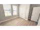 Bedroom features wood floor, two windows and a closet with double doors at 4063 Medicci Ln, Wesley Chapel, FL 33543