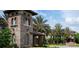 Stone entrance to the community, lush landscaping, and tall palm trees at 4063 Medicci Ln, Wesley Chapel, FL 33543