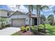 Charming single-Gathering home featuring a two-car garage, well-kept landscaping, and a welcoming front entrance at 4063 Medicci Ln, Wesley Chapel, FL 33543