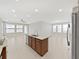 Open floor plan showcases an island kitchen with stainless steel appliances and tile flooring at 4063 Medicci Ln, Wesley Chapel, FL 33543