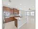 Bright kitchen with a large island, stainless steel appliances, and seamless flow to the living area at 4063 Medicci Ln, Wesley Chapel, FL 33543