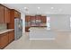 Open-concept kitchen boasts a center island, stainless steel appliances, and ample cabinet space at 4063 Medicci Ln, Wesley Chapel, FL 33543