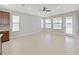 Spacious living room featuring tile floors, neutral walls, ceiling fan and lots of natural light at 4063 Medicci Ln, Wesley Chapel, FL 33543