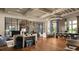 Open-concept living room with hardwood floors, exposed beam ceiling, bar, and modern decor at 4063 Medicci Ln, Wesley Chapel, FL 33543